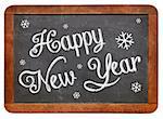 Happy New Year - white chalk text  on a vintage slate blackboard