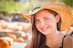 Preteen Girl Portrait Wearing Cowboy Hat at Pumpkin Patch in Rustic Setting.