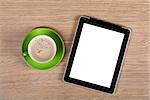Tablet with blank screen and coffee cup on office wooden table