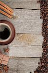Coffee cup, spices and chocolate on wooden table texture with copy space. View from above
