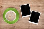 Cup of coffee and two photo frames on wooden table