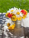 Fresh garden colorful flowers bouquet in vase on wooden table