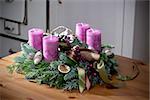 Advent wreath of twigs with purple candles and various ornaments