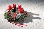 Advent wreath of twigs with red candles and various ornaments