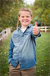 Handsome Young Boy Giving the Thumbs Up in the Park.