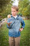 Handsome Young Boy Tossing Up His Baseball in the Park.