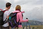 Young backpackers searching the destination in the mountains while hiking