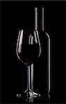 Glass and bottle of red wine on black background
