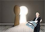 Composite image of businesswoman dropping many folders in room with door shaped as keyhole