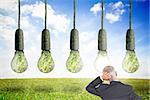 Composite image of doubtful mature businessman looking at green light bulb hanging in sky