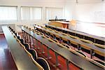 View of empty wooden seats with tables in a lecture hall