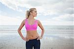 Beautiful toned woman standing with hands on hips on the beach