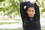 Close up of a healthy young woman stretching her hands during exercise at the park