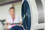 Determined young woman working out on row machine in fitness studio