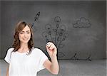 Composite image of smiling businesswoman holding marker