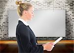 Composite image of blonde businesswoman holding tablet