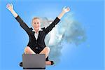 Composite image of attractive blonde businesswoman sitting in front of laptop with arms up