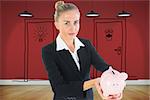 Composite image of blonde businesswoman holding piggy bank