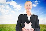 Composite image of blonde businesswoman holding piggy bank