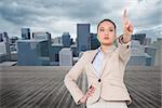 Composite image of unsmiling asian businesswoman pointing