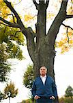 Portrait of Senior Man Leaning Against Tree, Mannheim, Baden-Wurttemberg, Germany