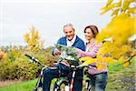 Couple with Bicycles Looking at Map in Autumn, Mannheim, Baden-Wurttemberg, Germany