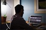 Man sitting at desk using laptop