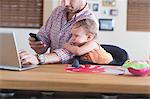 Man working at kitchen counter with baby sitting beside