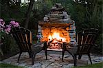 Two chairs in front of outdoor fireplace