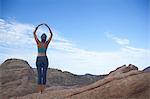 Woman doing yoga at Vazquez Rocks, hands together above her head