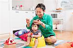 Father cutting baby's hair on floor