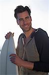 Young man holding surfboard, San Diego, California, USA