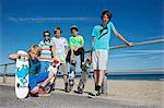 Portrait of five boys with skateboards at coast