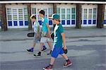 Three boys carrying skateboards