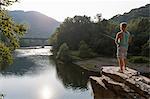 Young man fishing from rock ledge, Hamburg, Pennsylvania, USA