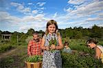 Portrait of girl holding bunch of leaves on family herb farm