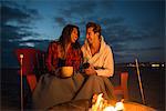 Young couple by campfire, San Diego, California, USA