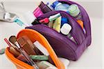 Women's toiletry and cosmetic travel bag on bathroom counter, filled with toothbrush, lotion, makeup and other beauty products, USA