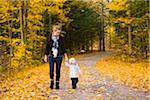 Mother walking on Country Road with Baby Daughter in Autumn, Scanlon Creek Conservation Area, Ontario, Canada