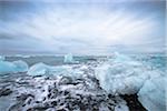 View of the glacial lagoon, landscape with blue iceberg, foaming sea and cloudy blue sky, Jokulsarlon, Skaftafell, Iceland, Europe