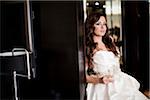 Portrait of young woman in wedding gown, holding glass of champagne and looking at camera, Ontario, Canada