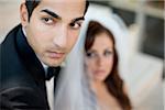 Close-up portrait of groom, with bride in the background, Ontario, Canada