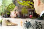 Close-up portrait of bride and groom sitting indoors next to window, with reflections in glass, Ontario, Canada