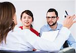 Backview of businesswoman in discussion with young couple, Germany