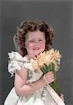 1940s 1950s PORTRAIT SMILING BRUNETTE GIRL HOLDING BOUQUET OF YELLOW JONQUILS LOOKING AT CAMERA