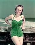 1940s PORTRAIT SMILING WOMAN WEARING GREEN VELVET BATHING SUIT POSING LEANING ON DIVING BOARD