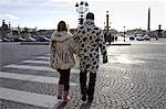 Pedestrians in winter coats walking across cobbled road on zebra crossing in Place de la Concorde, Central Paris, France