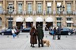 Couple with dog gaze at Ritz Hotel in Place Vendome, Central Paris, France