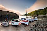 Fishing vessels beached at low tide in Clovelly harbour, Devon, England, United Kingdom, Europe