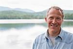 A man on the shore of a lake in New York state.